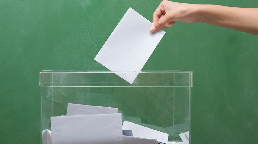 Personne déposant un bulletin dans l'urne. Elections municipales 2020 dans l'Aude.