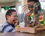 ENFANT HANDICAPÉ QUI JOUE AVEC UN  ADULTE