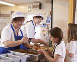 Dame servant le repas à une élève à la cantine