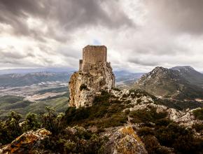 vue d'un panorama sur une vallée avec une ruine au milieu