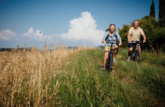 UN HOMME ET UNE FEMME SE BALADANT A VELO DANS LA CAMPAGNE