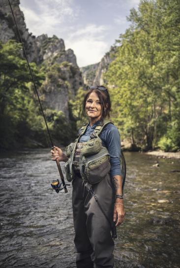 Lenka Stary tient une canne à pêche dans un fleuve de l'Aude