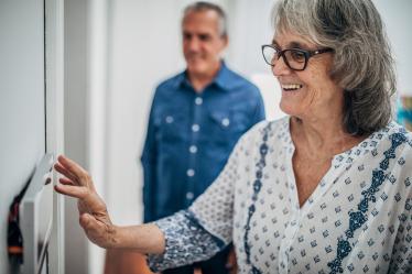 Personne âgée se servant de la domotique dans son appartement.