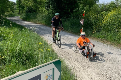 Handbikeur et cycliste circulent le long du canal du Midi.