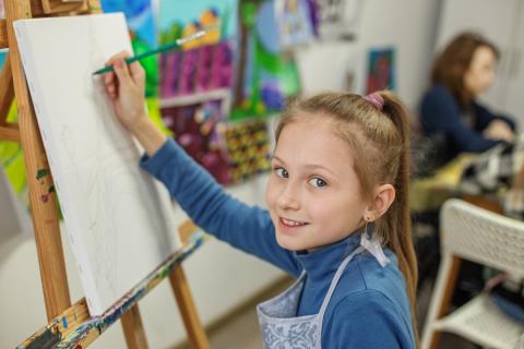 Jeune fille en train de dessiner devant un chevalet
