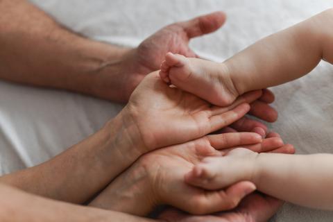 pieds d'un nourrisson dans les mains de ses parents