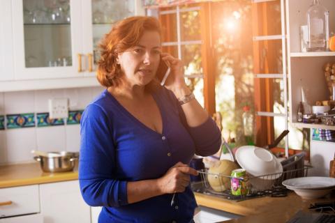 Femme téléphonant dans sa cuisine.
