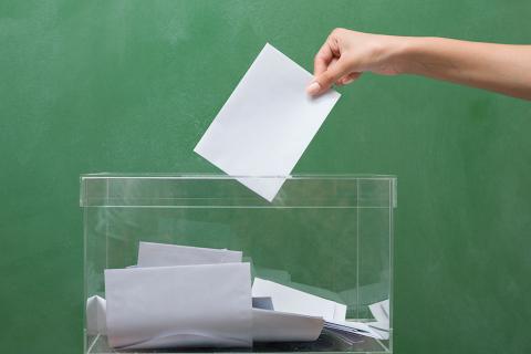 Personne déposant un bulletin dans l'urne. Elections municipales 2020 dans l'Aude.