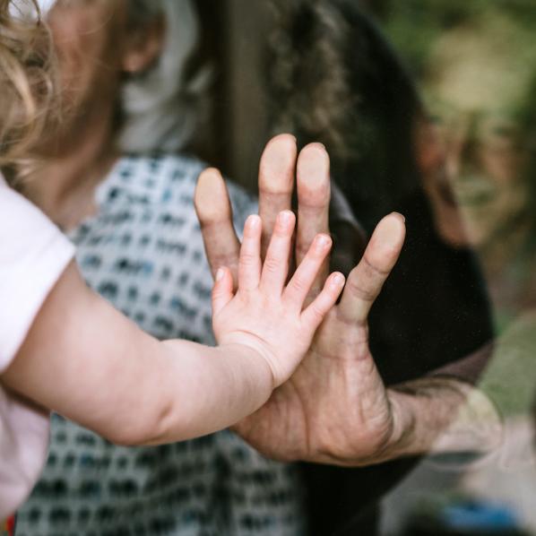 Main d'une petite fille contre la main d'un senior.