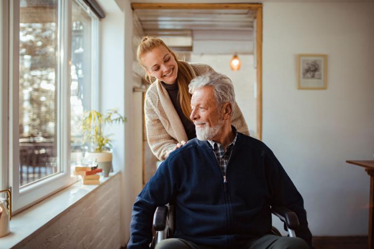 Jeune femme poussant un homme dans un fauteuil roulant