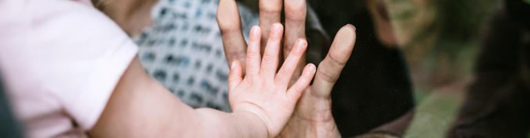 Main d'une petite fille contre la main d'un senior.