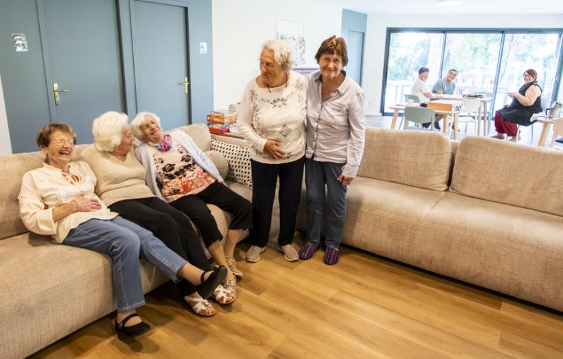 personnes âgées riant sur un canapé