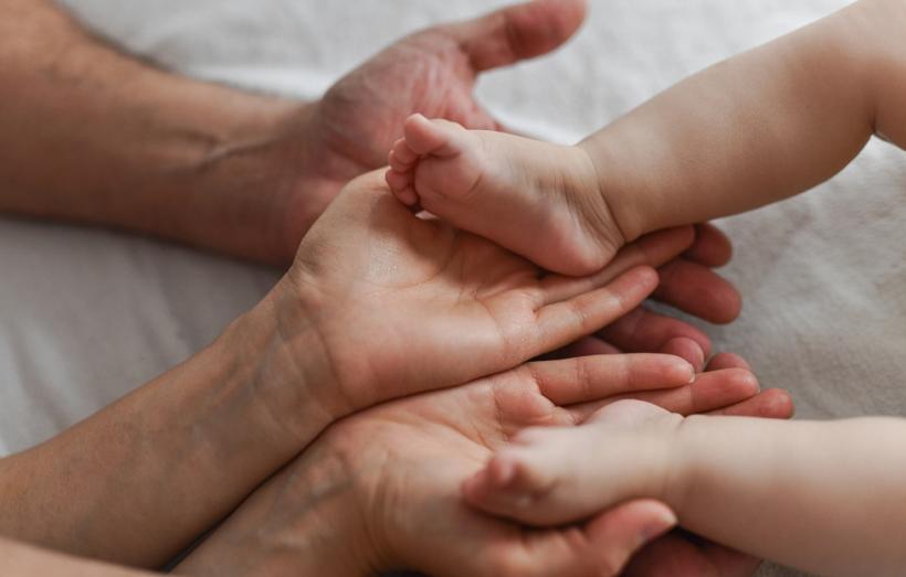 pieds d'un nourrisson dans les mains de ses parents