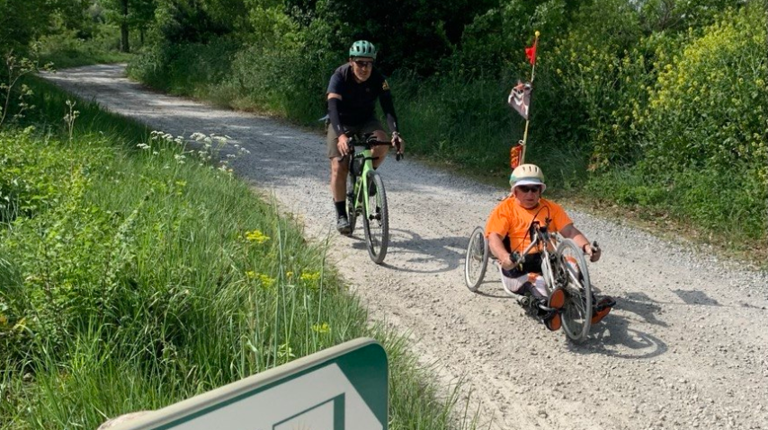 Handbikeur et cycliste circulent le long du canal du Midi.