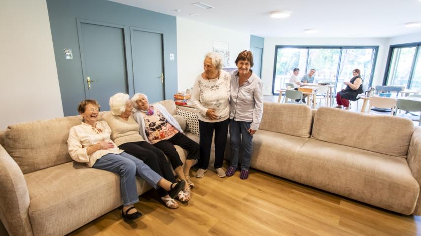 personnes âgées riant sur un canapé