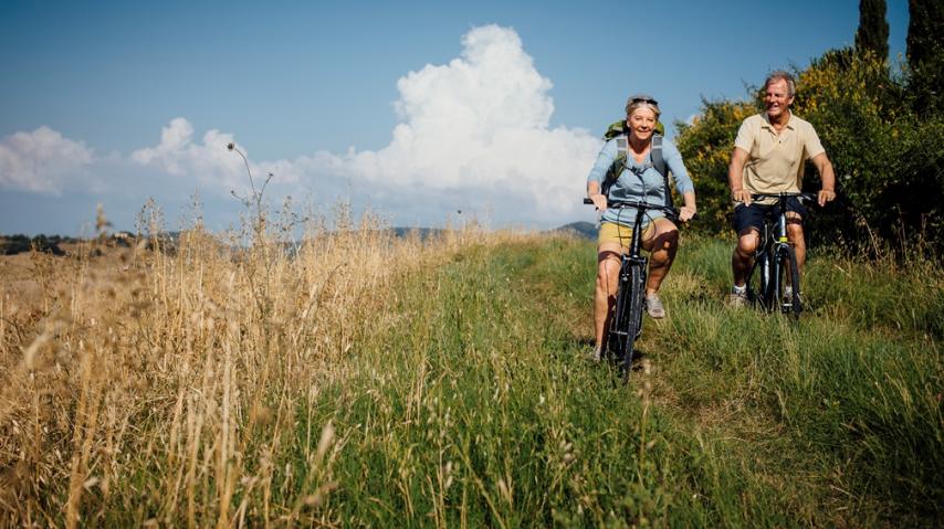 UN HOMME ET UNE FEMME SE BALADANT A VELO DANS LA CAMPAGNE