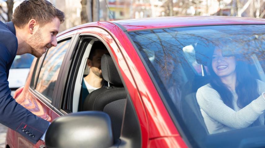 Jeune homme faisant du covoiturage avec une conductrice