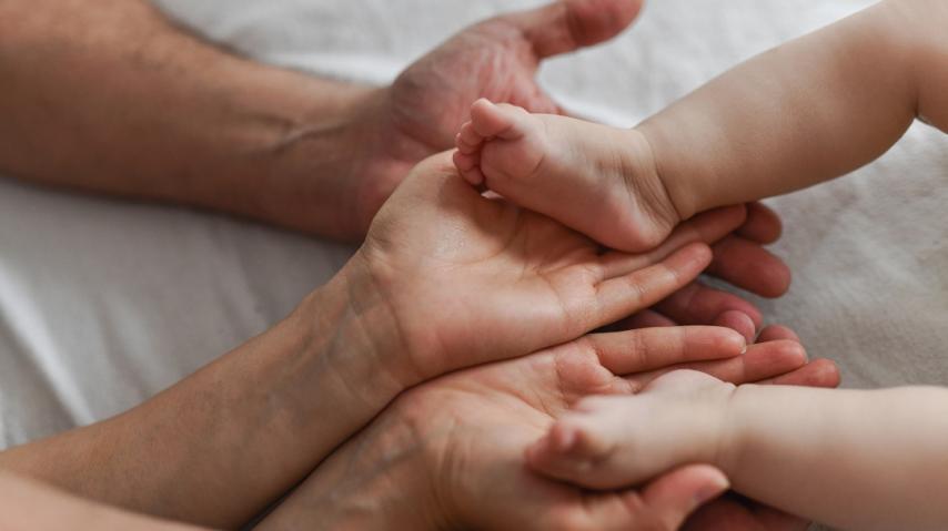 pieds d'un nourrisson dans les mains de ses parents
