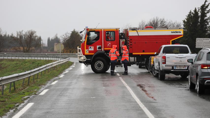 Un camion de pompiers barre une route inondée, dans l'Aude