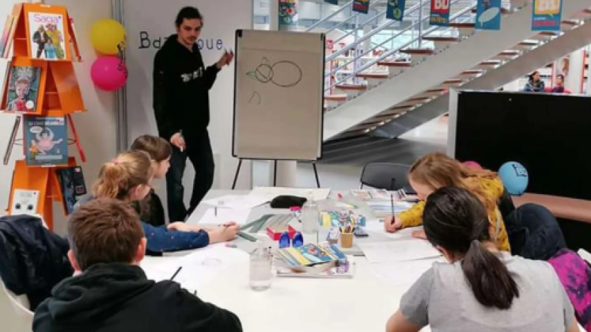 Un dessinateur à l'oeuvre devant des jeunes, lors d'une précédente édition de Sortie de case, dans l'Aude.