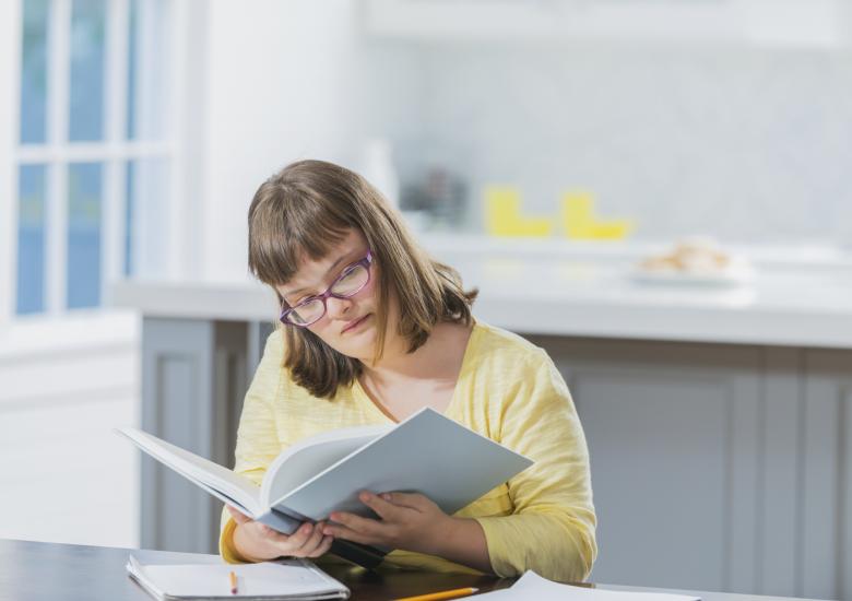 Une jeune femme lit un livre qu'elle a emprunté à une bibliothèque adaptée